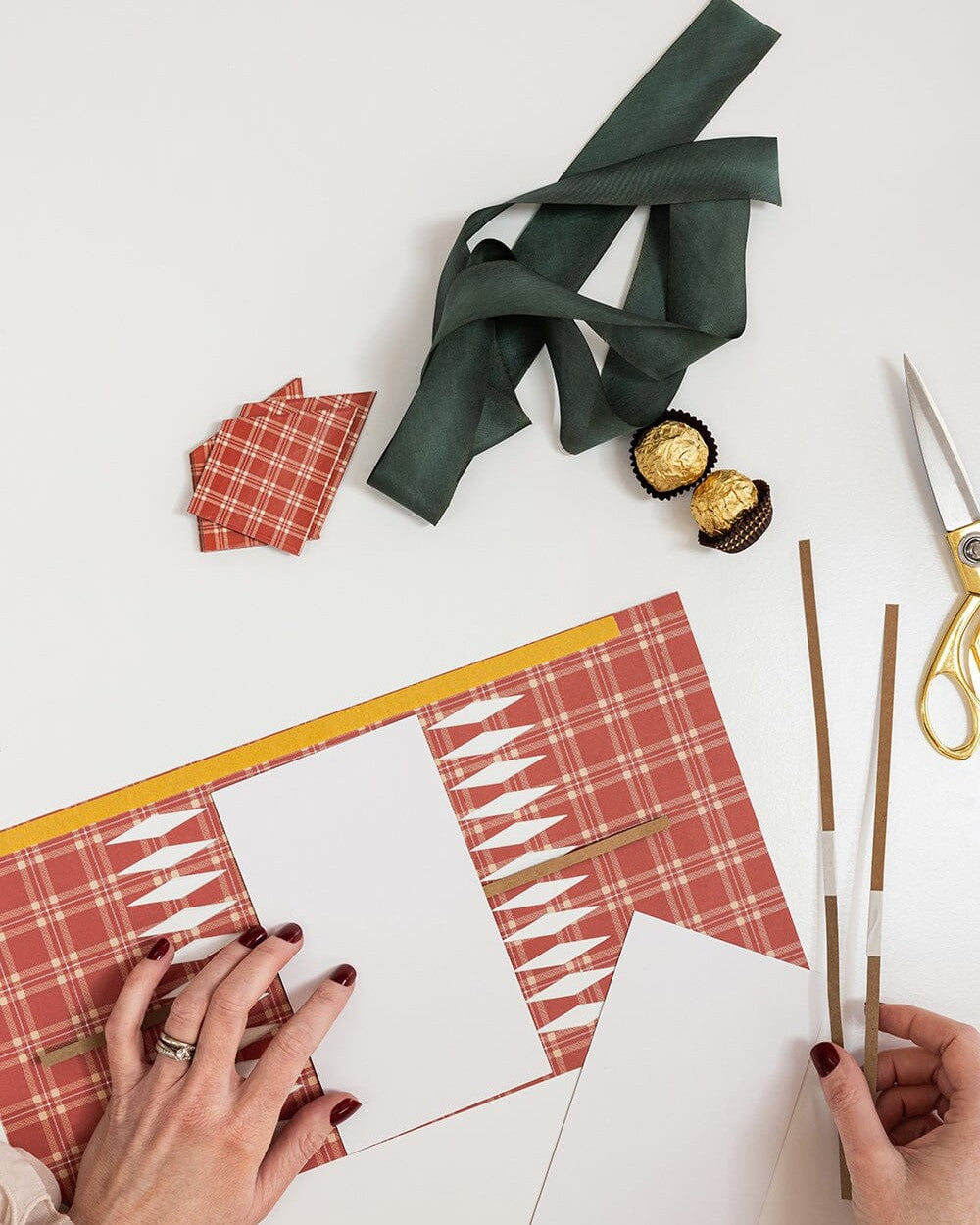 Making Heirloom Holly crackers with the printed wrappers, cracker snaps, ribbon and scissors