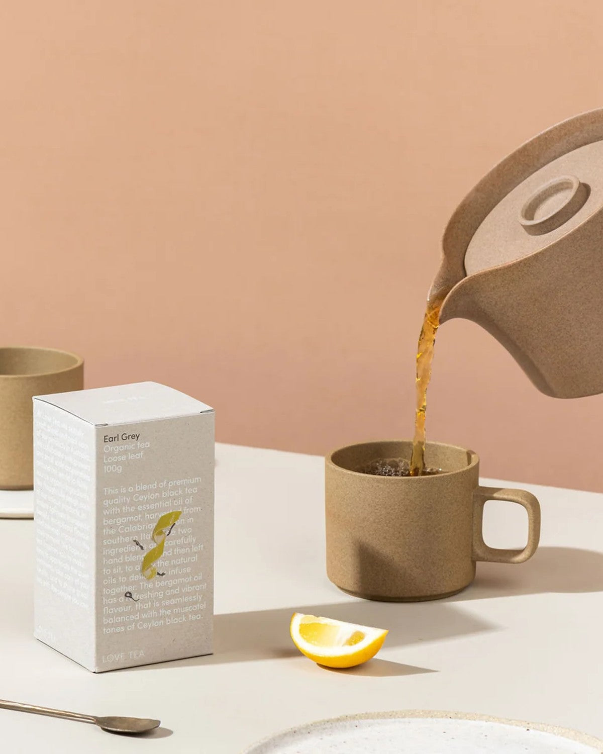 Love Tea Earl Grey tea box with tea poured into a mug and a lemon wedge