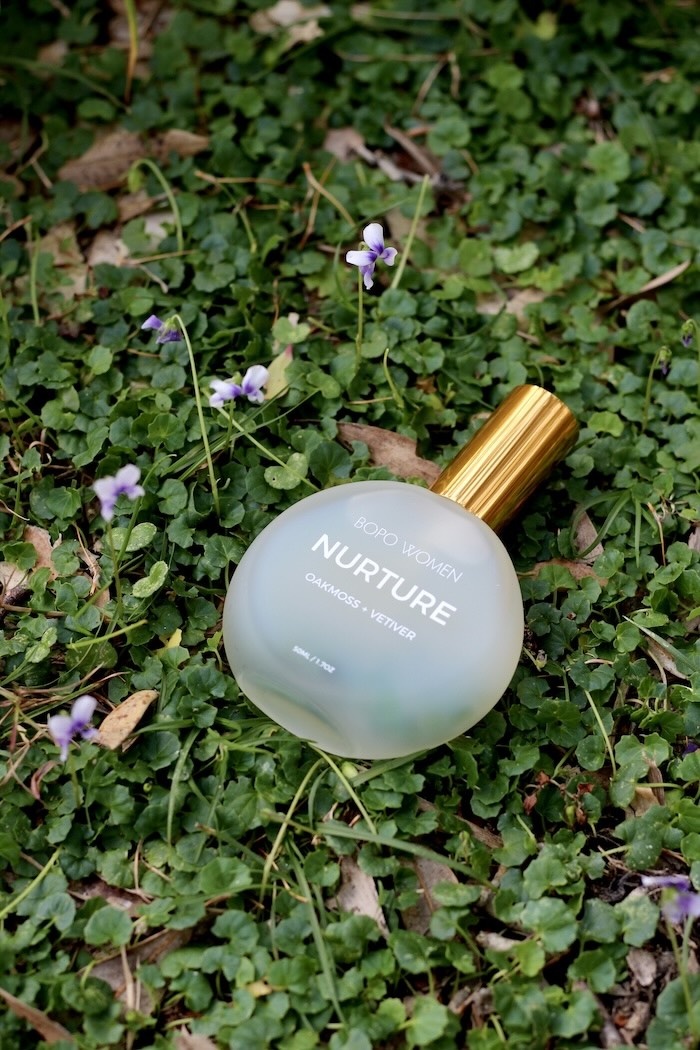 Aromatherapy Perfume bottle from Bopo Women Nurture' on a bed of native violets with small flowers