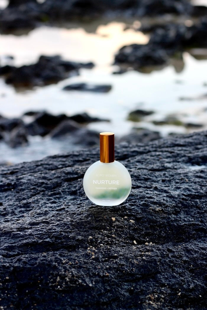 Aromatherapy Perfume bottle "Nurture" by Bopo Women on a rocky surface at the beach with water in the background at Black Head Ballina