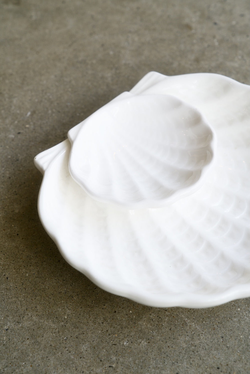 White ceramic shell dish, two tier on concrete